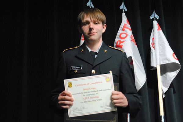 student on stage holding a certificate