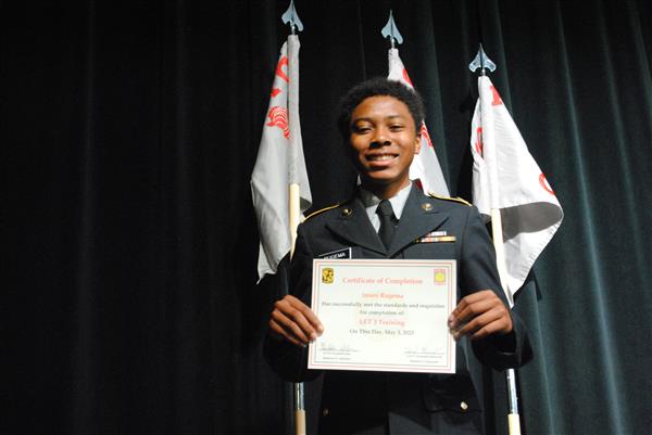 student on stage holding a certificate