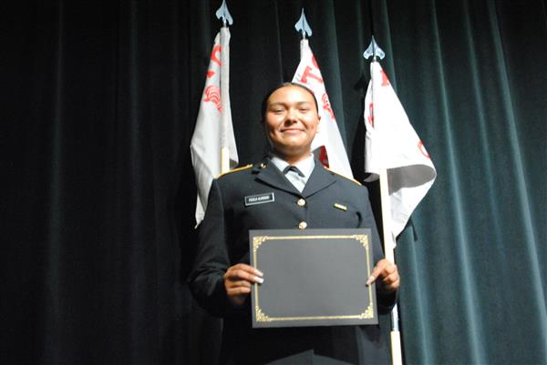 student on stage holding a certificate