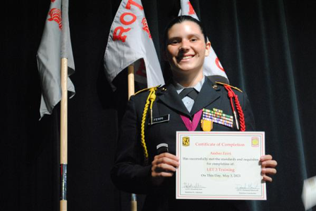 student on stage holding a certificate