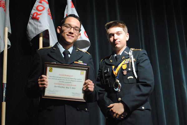 students on stage holding certificates