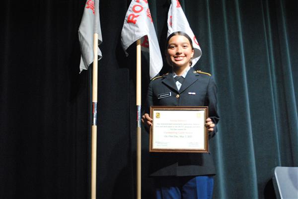 student on stage holding a certificate