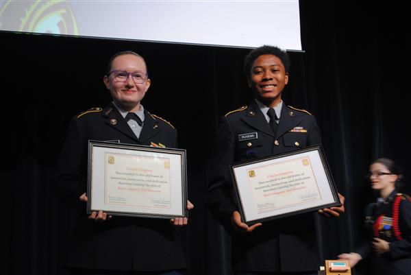 students on stage holding certificates