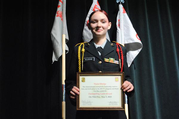 student on stage holding a certificate