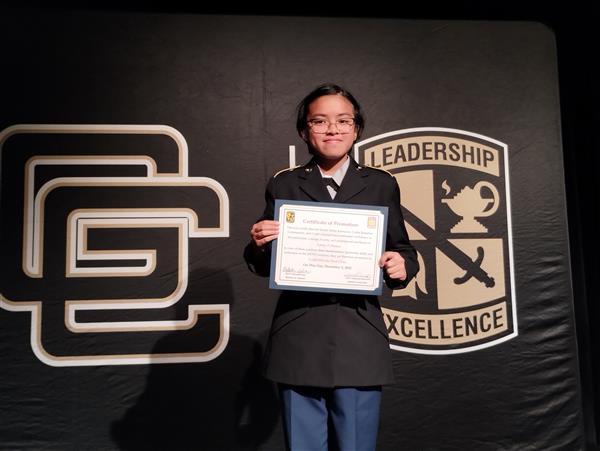 student on stage holding a certificate