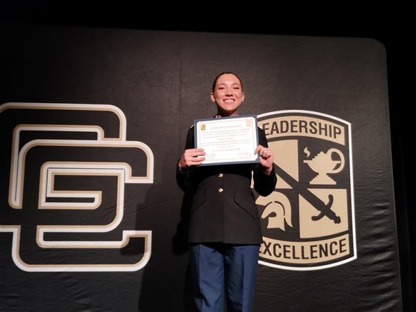 student on stage holding a certificate