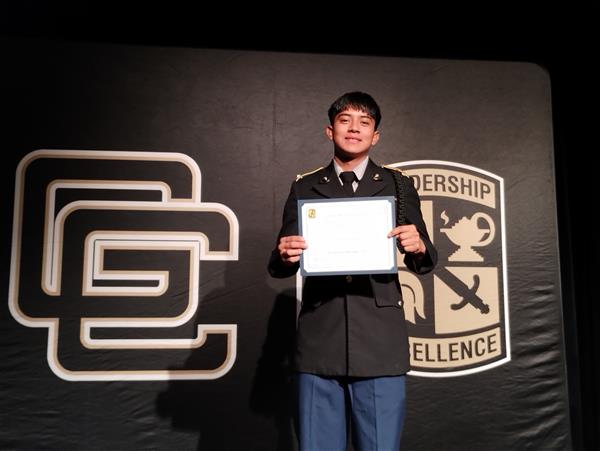 student on stage holding a certificate