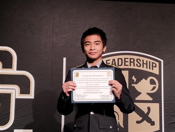 student on stage holding a certificate