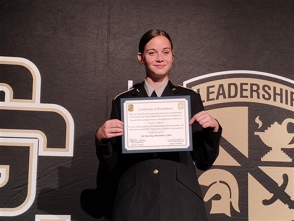 student on stage holding a certificate