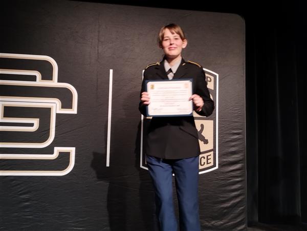 student on stage holding a certificate