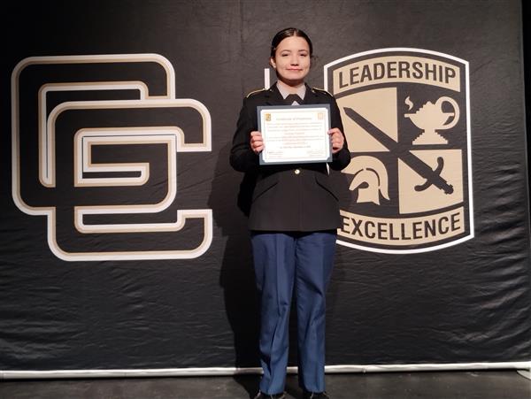 student on stage holding a certificate