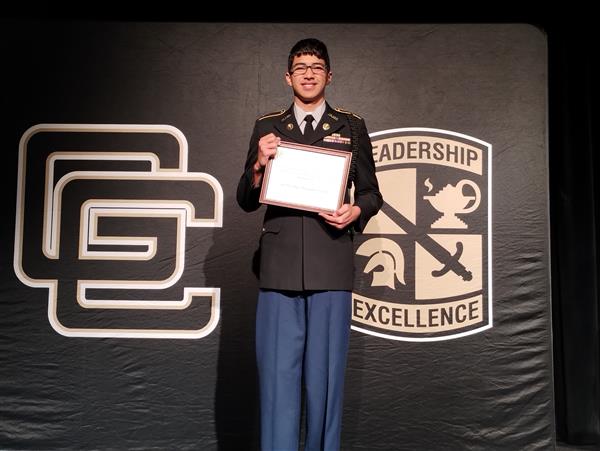 student on stage holding a certificate