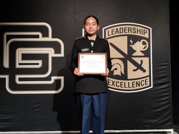 student on stage holding a certificate