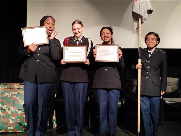 students on stage holding certificates