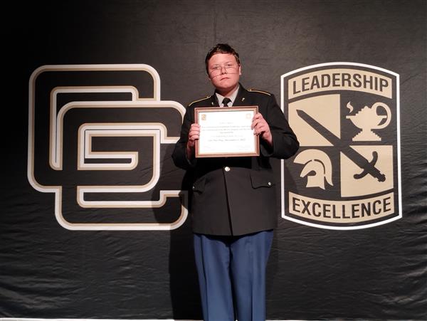 student on stage holding a certificate