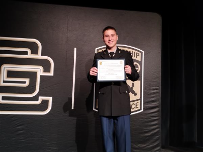 student on stage holding a certificate