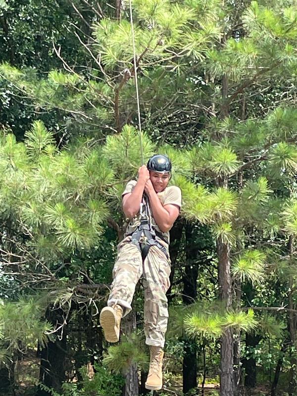 student holds on tightly while ziplining