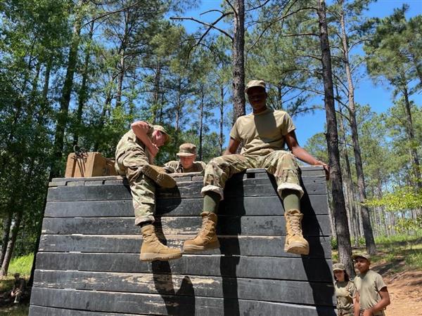 two students sit at the top of a wooden wall