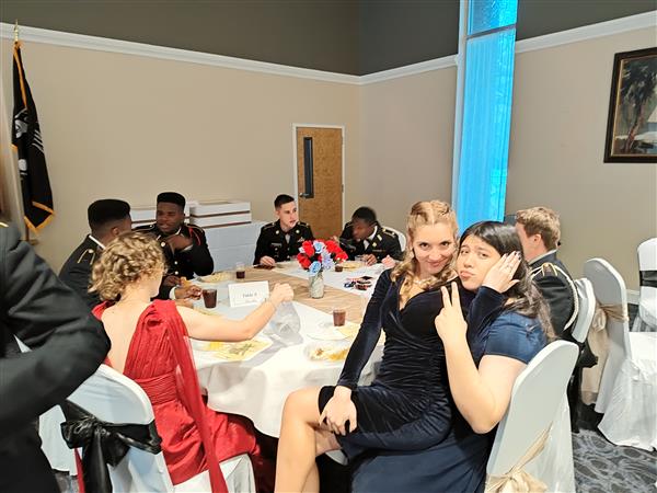 two students at a table turn to pose for the camera