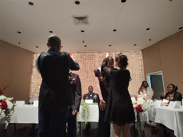 two people place crowns on two students' heads