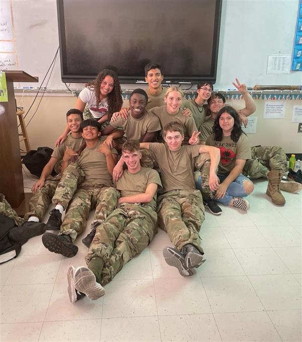 a group of eleven people sitting on the floor of a classroom