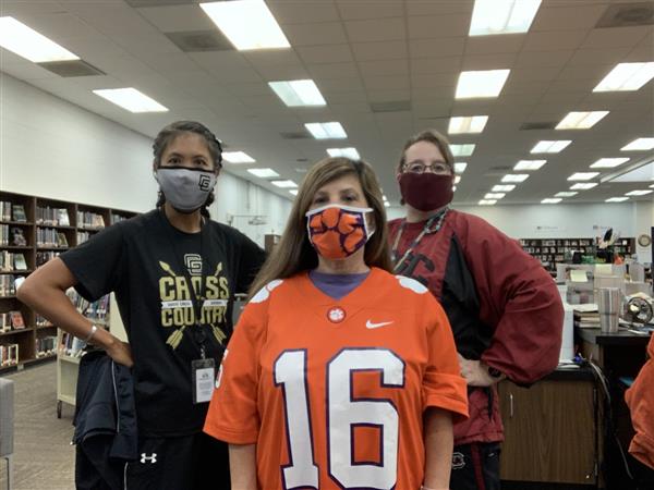 Three people pose in the media center