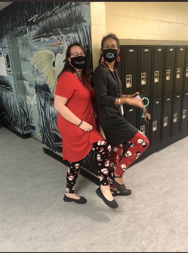 Two people stand at the corner of a hall wearing winter-themed leggings