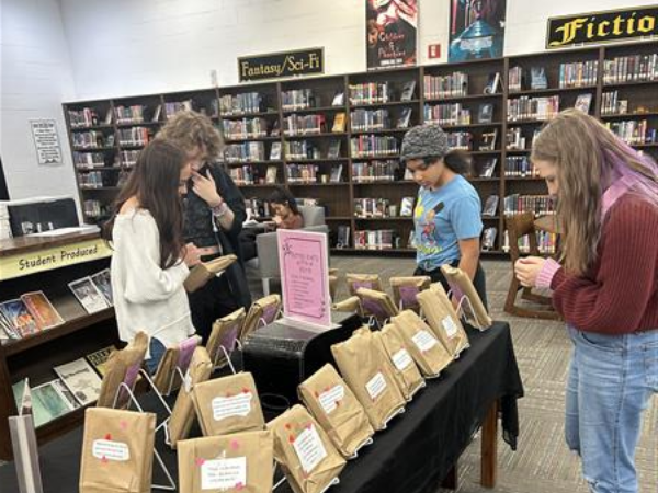 four students look at a display of wrapped books