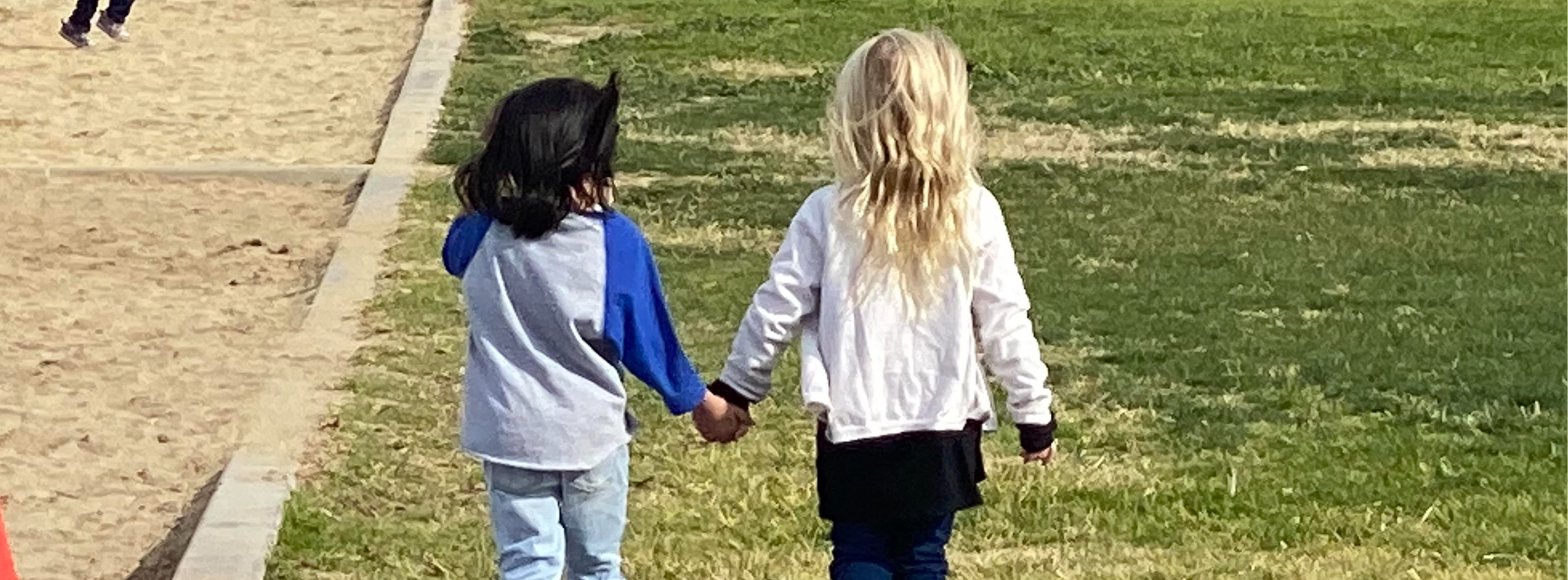 Tiny friends walk holding hands