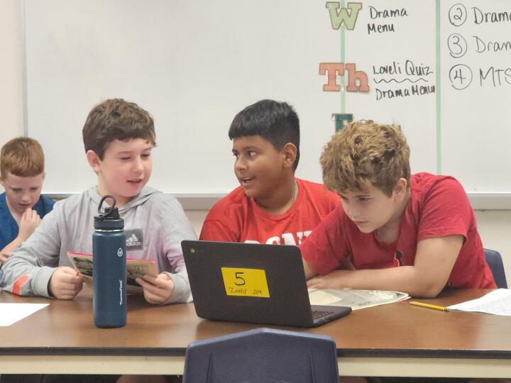 A group of students working on a laptop