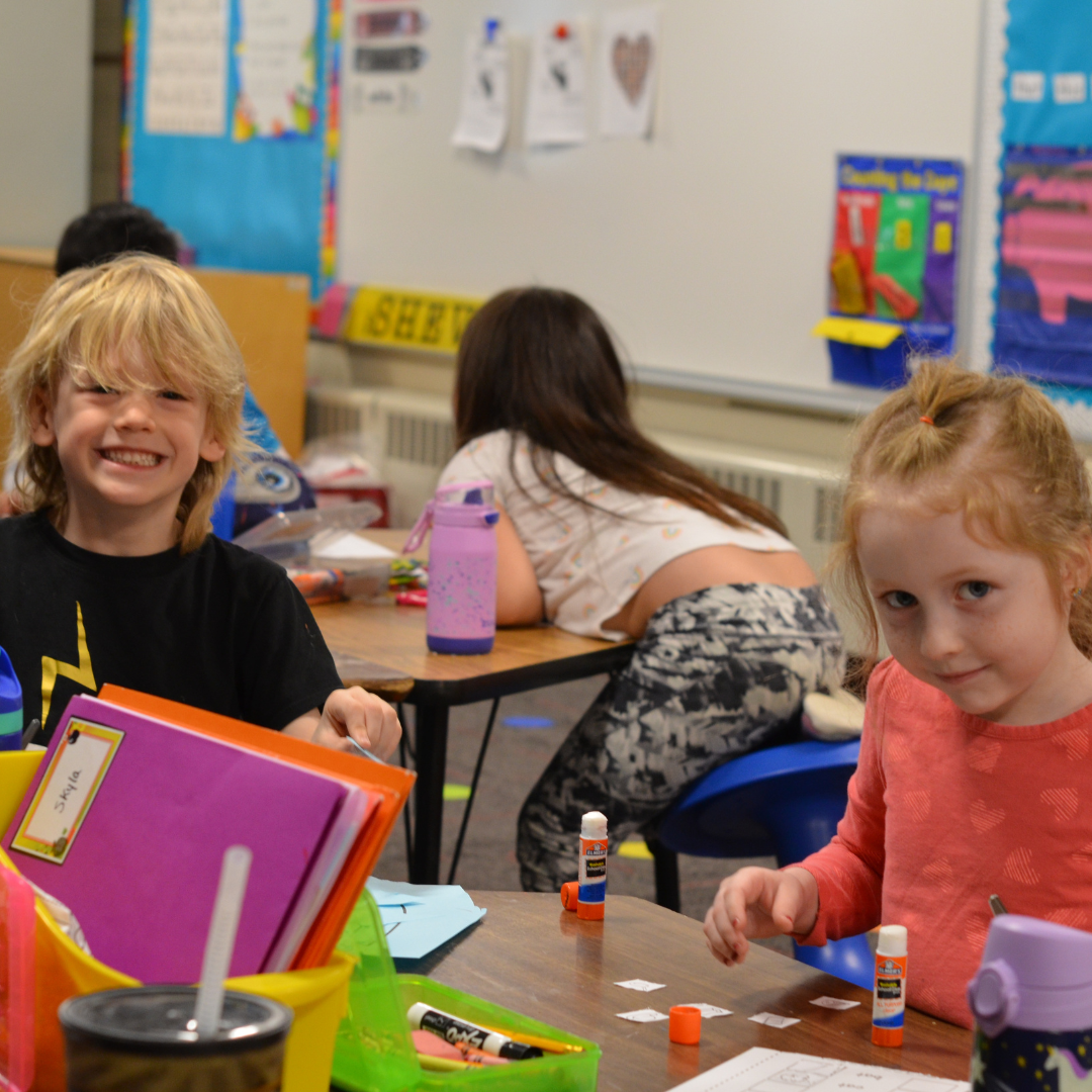 students smiling while doing crafts