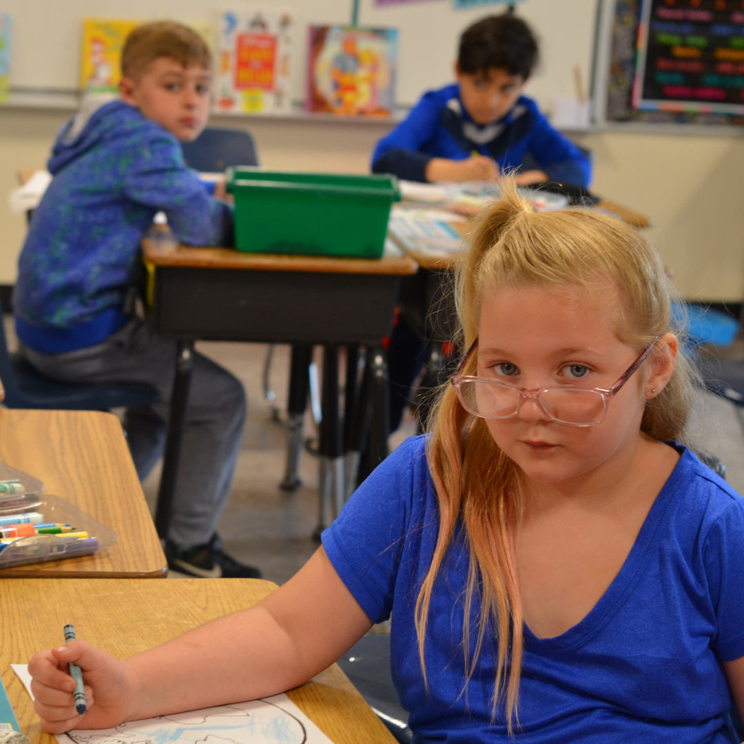 student looking at camera while doing work