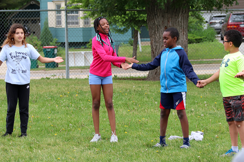students on playground clapping hands