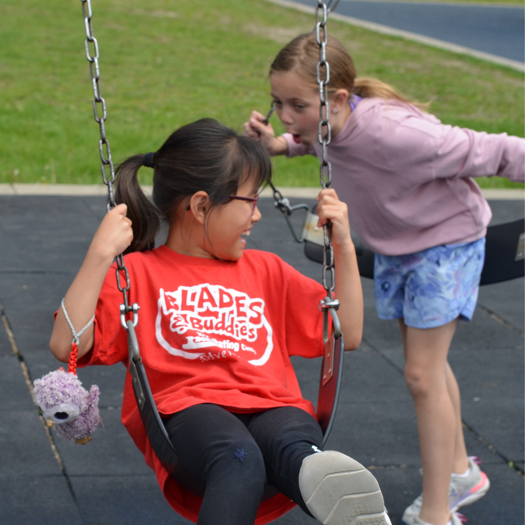 student laughing while being pushed on swing