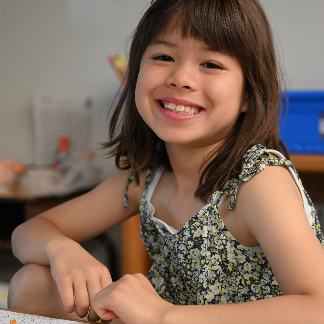 student sitting in her chair smiling