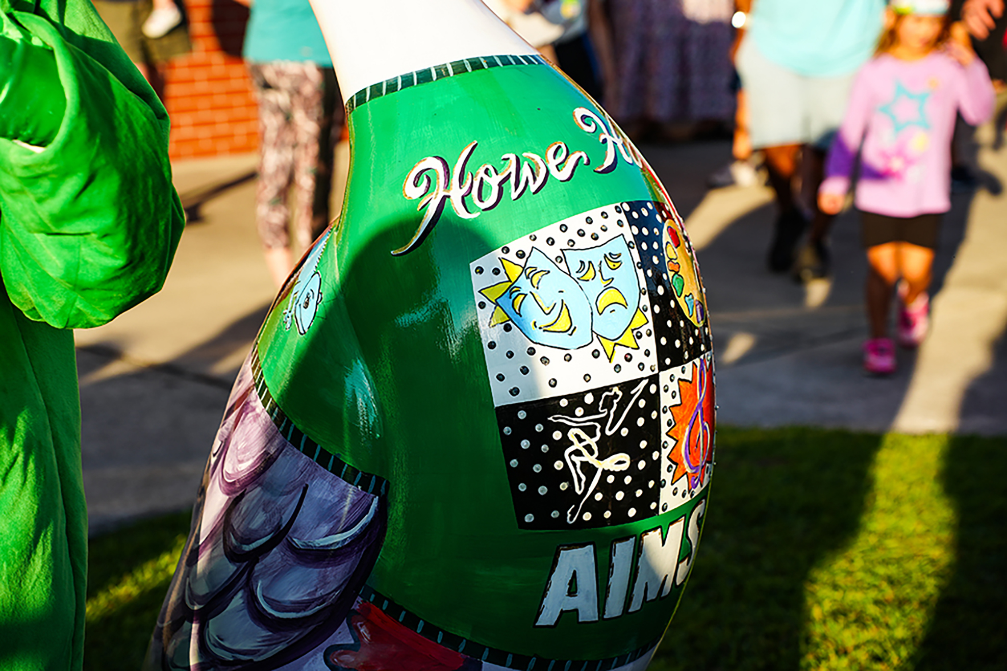 A colorful, abstract sculpture of an animal with patches. Words like "Howe" and "AIM" are visible.