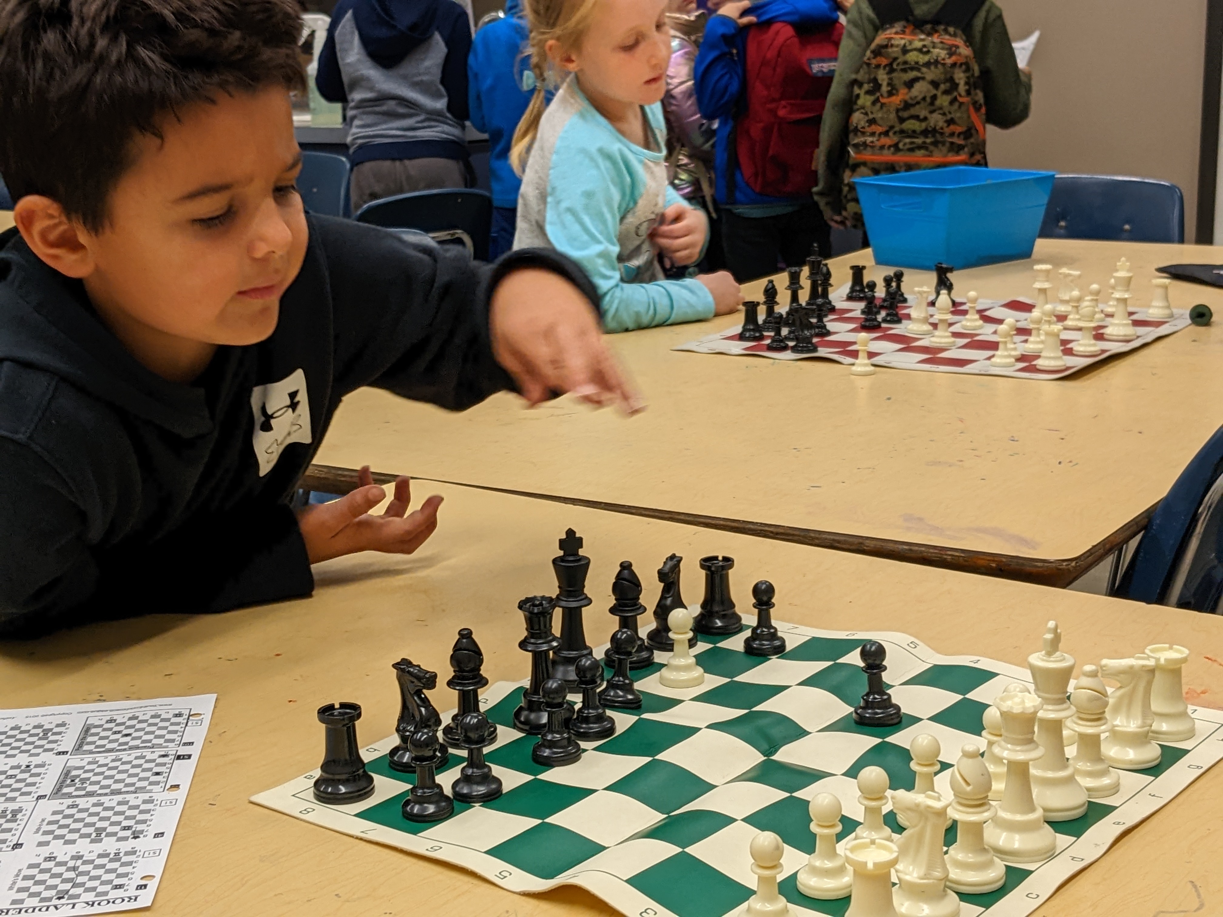 Student places a chess piece during a game