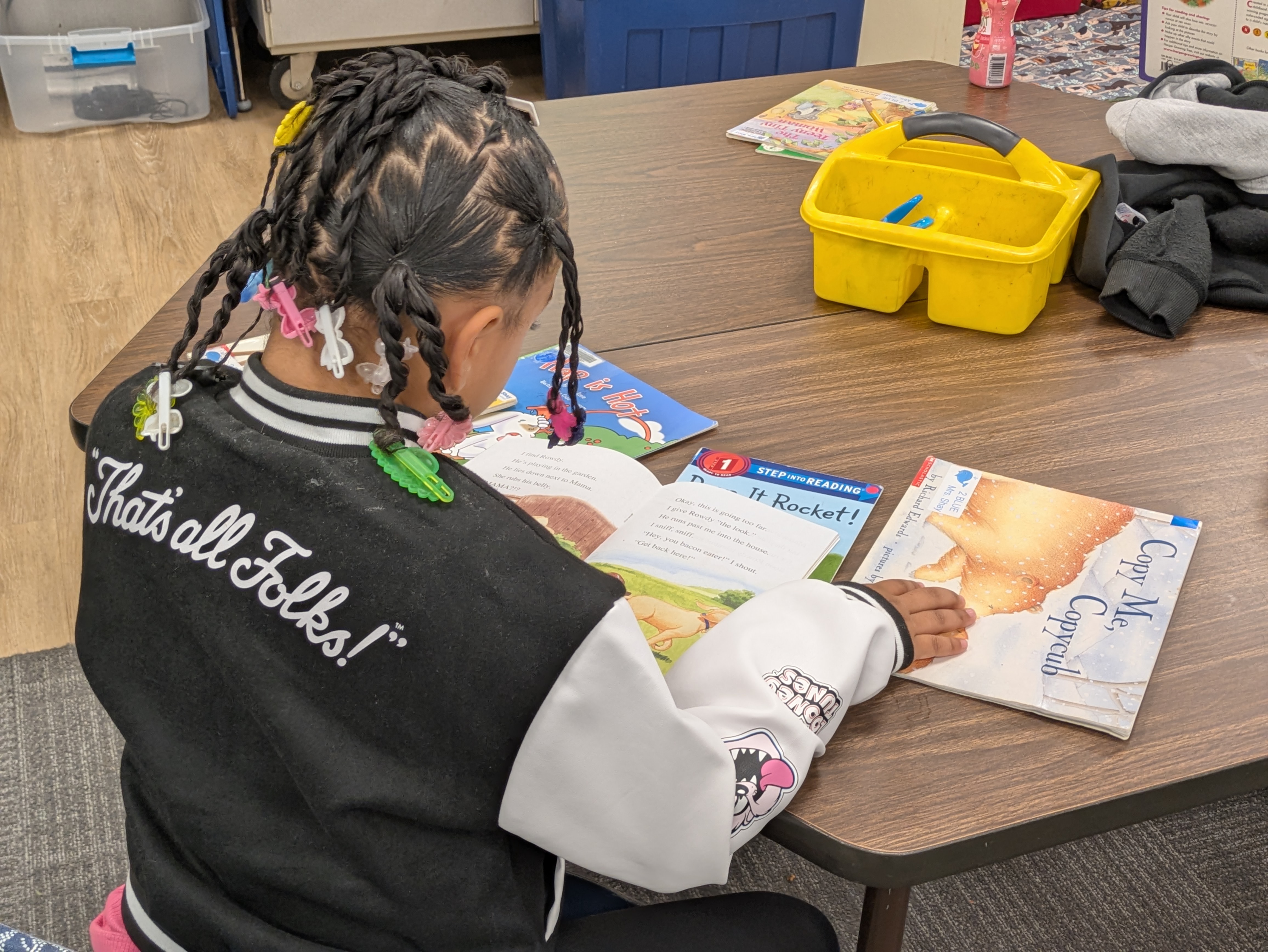 A girl is reading a book on a table at school