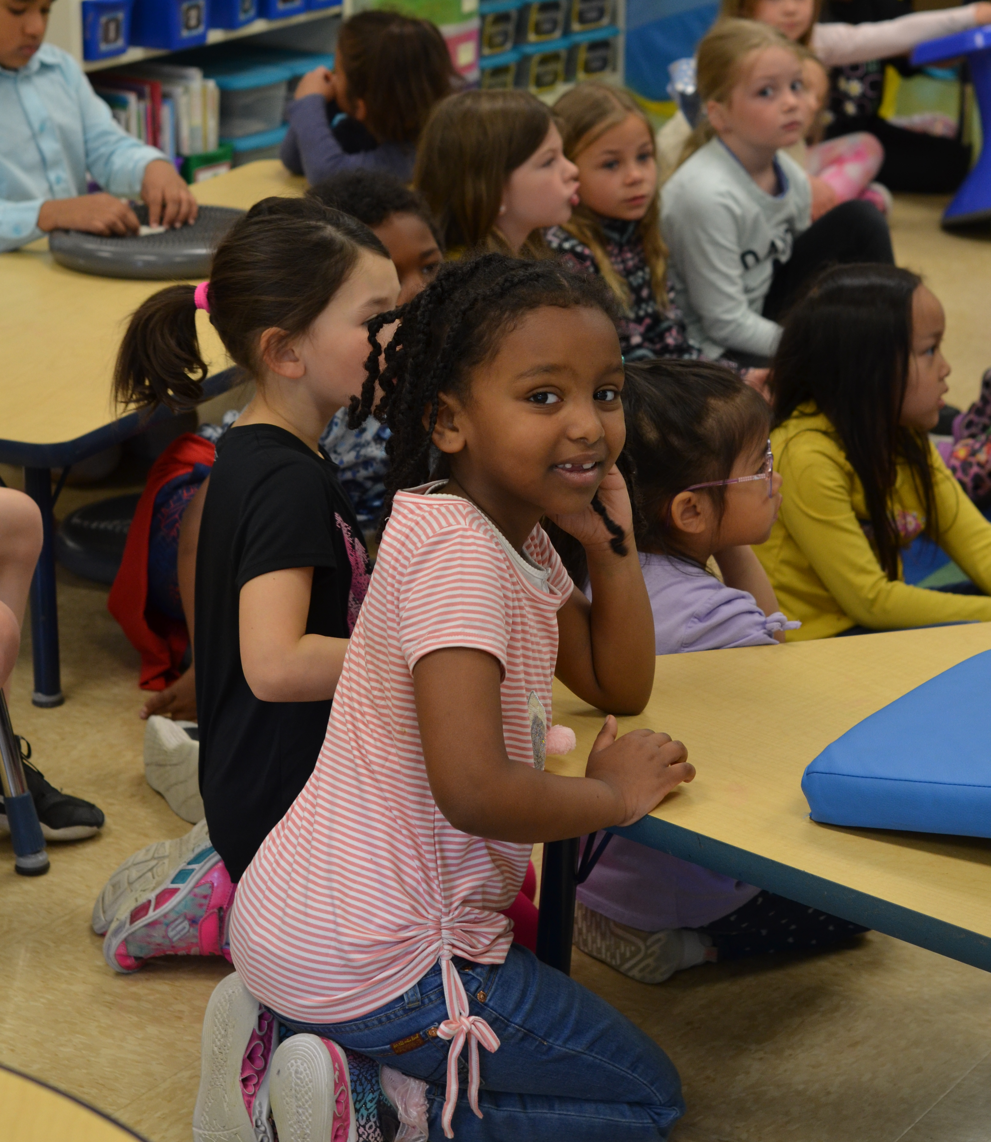 students sitting on carpet in classroom