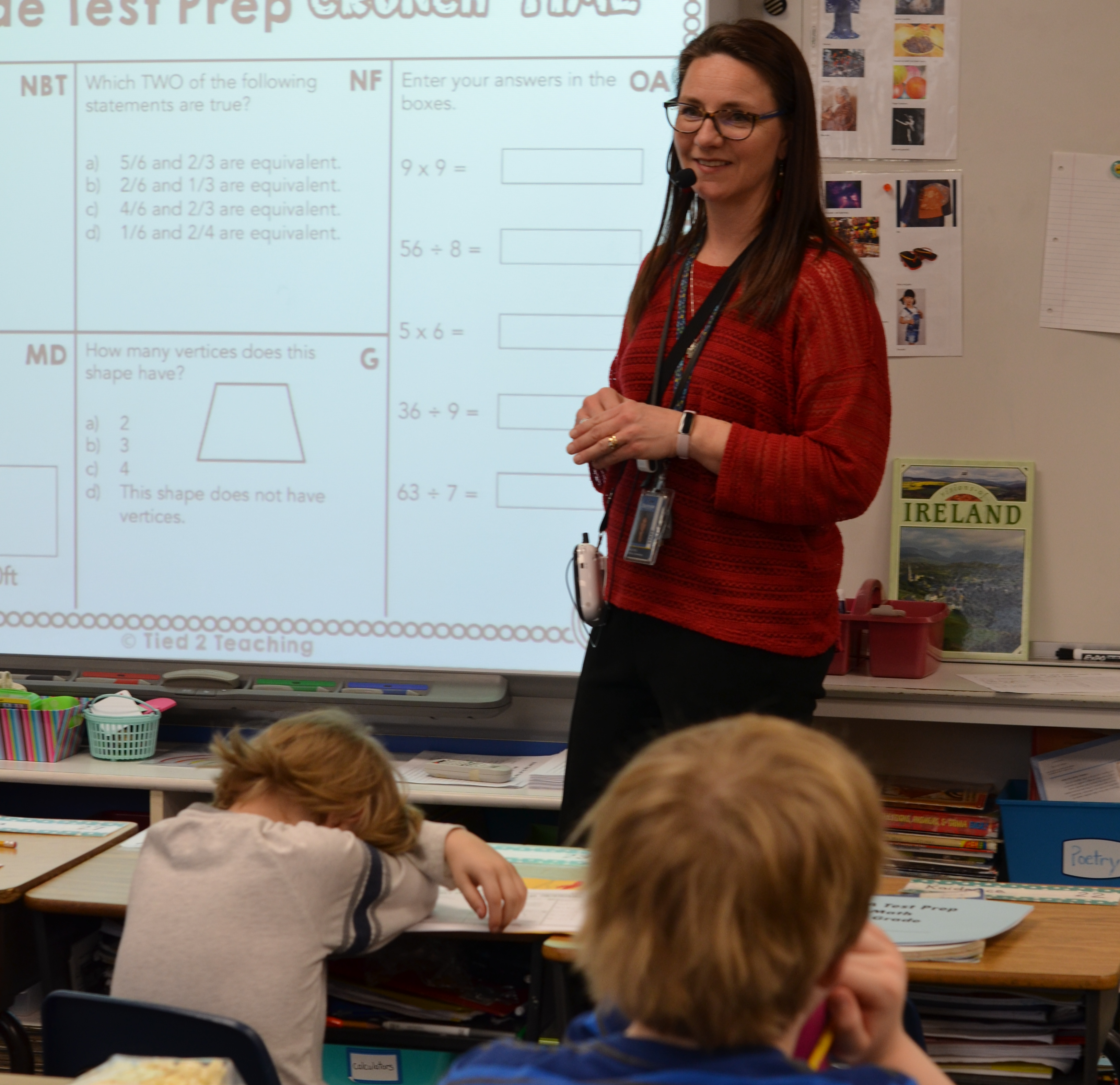 teacher standing by whiteboard looking at students