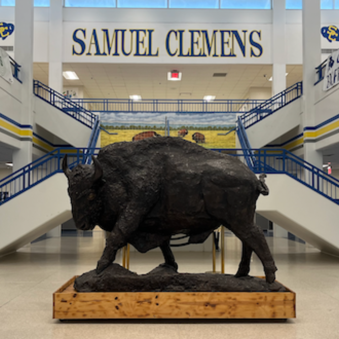 buffalo statue in front of staircases with "samuel clemens" in blue & yellow lettering in background