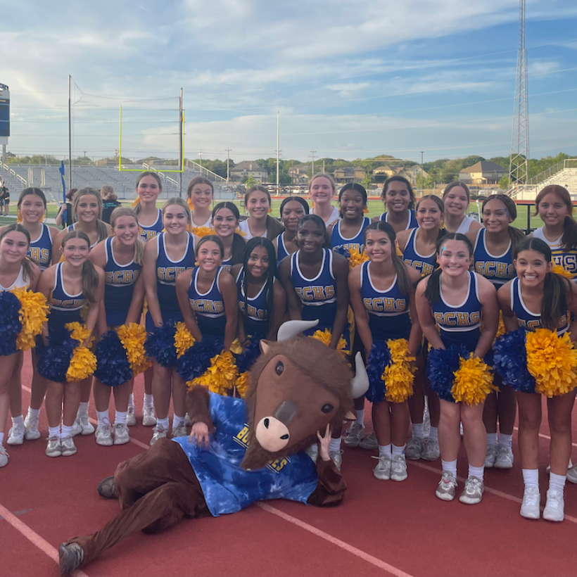 samuel clemens cheer squad in blue uniforms smiling with buffalo mascot reclining in foreground