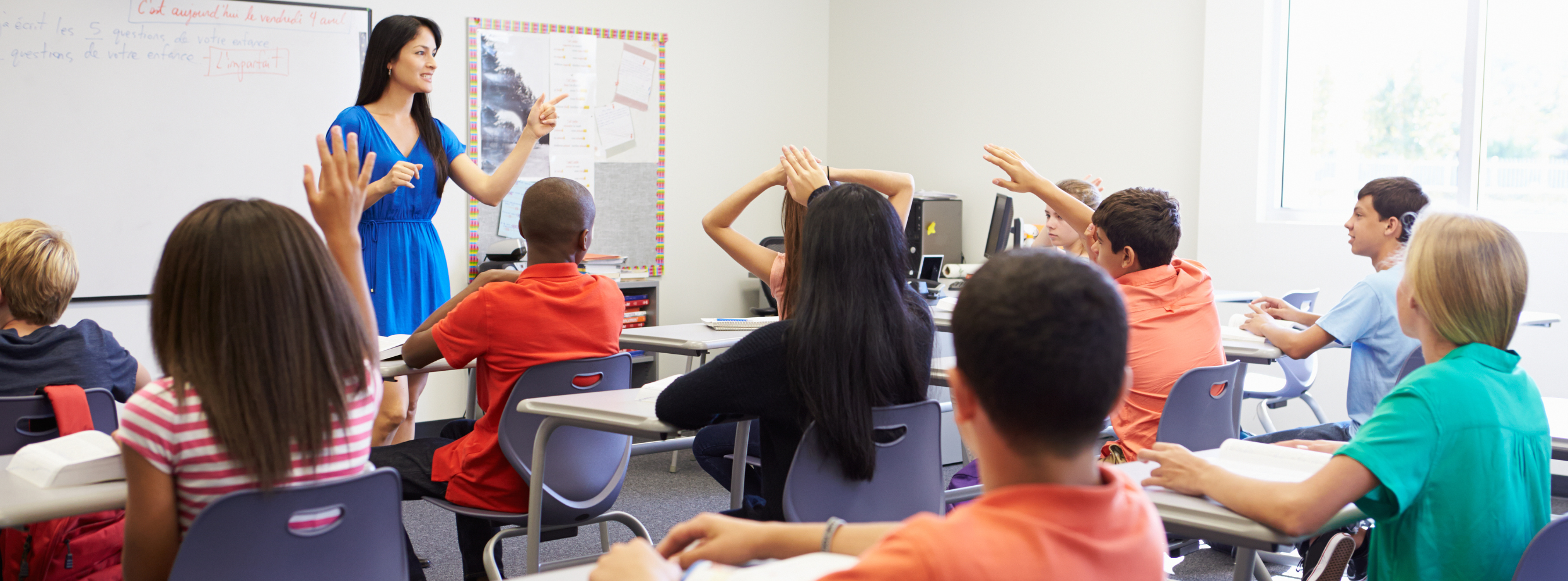 Students raising hands in class