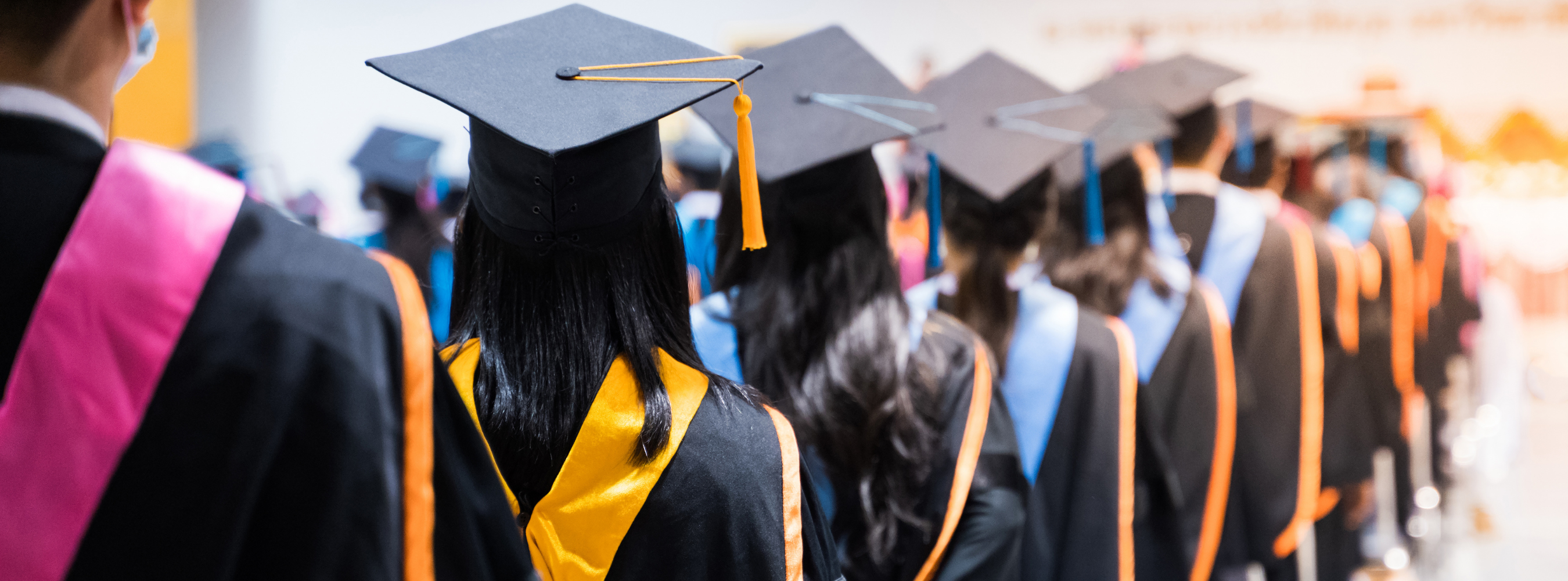High school graduates standing in a line with their backs turned