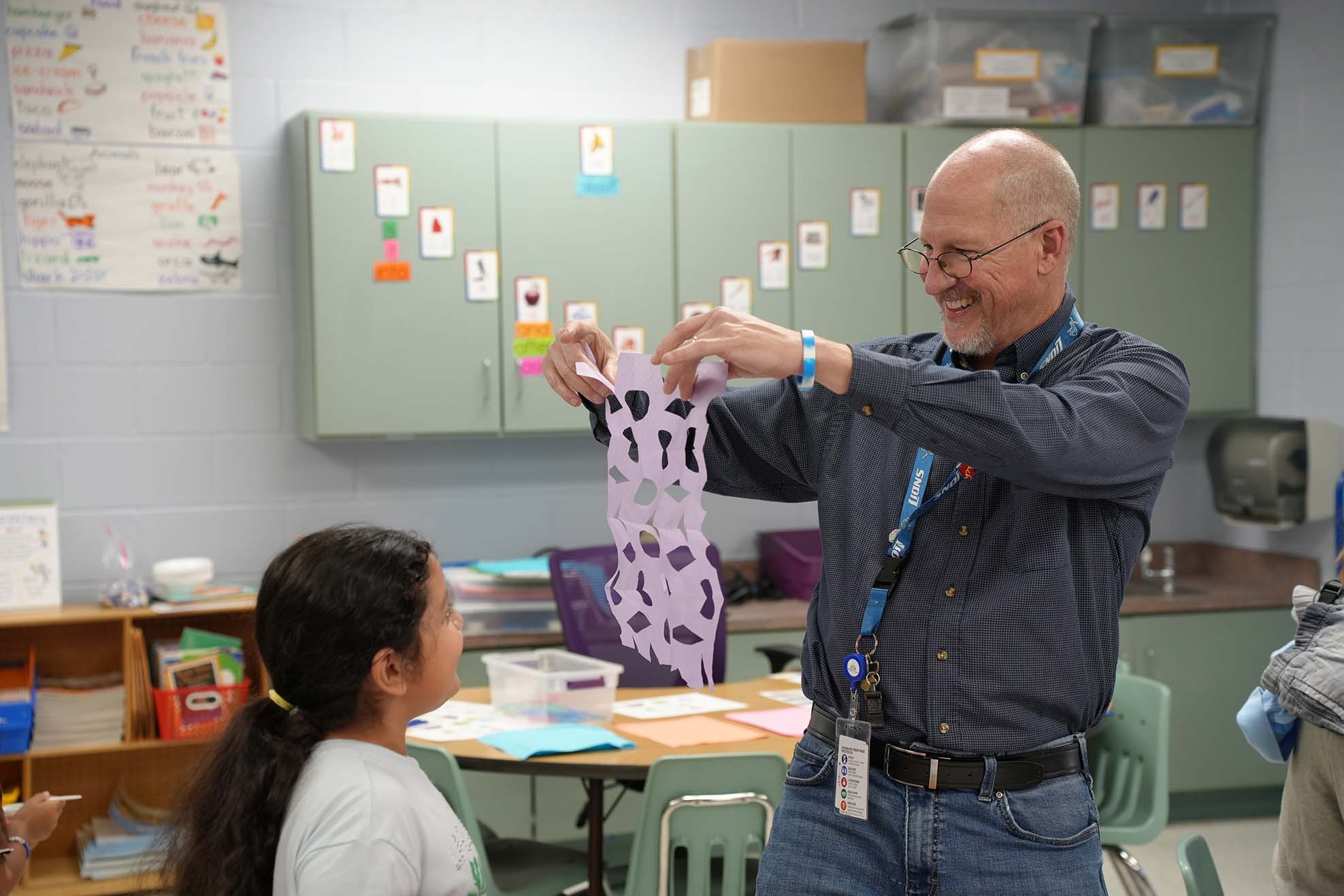 teacher doing craft activity with student