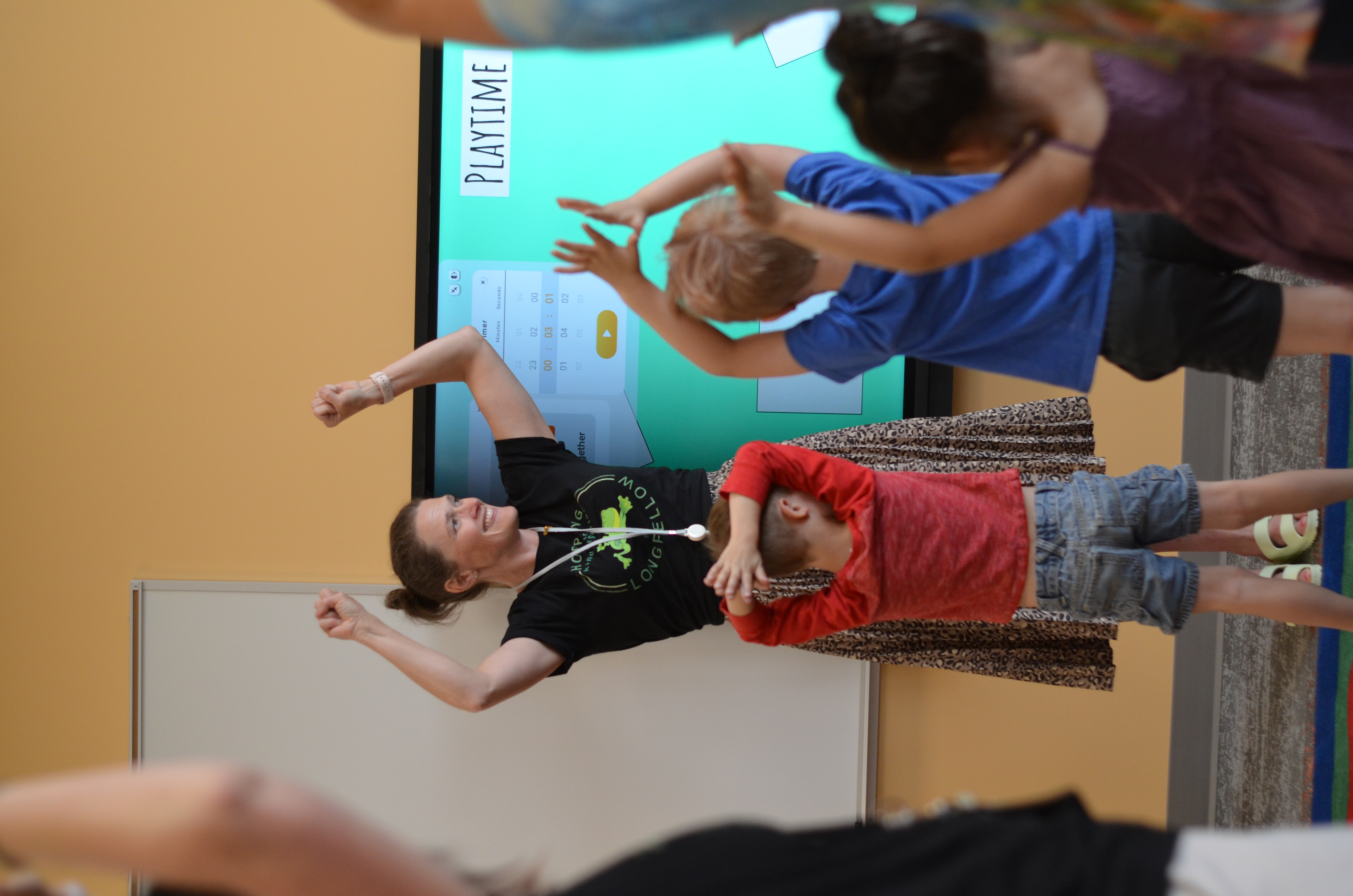 teacher dancing with preschool students in classroom