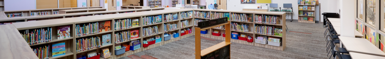 Interior perspective of the Library Media Center looking at a u shape of bookcases and a pretend play stand in the middle of the room.