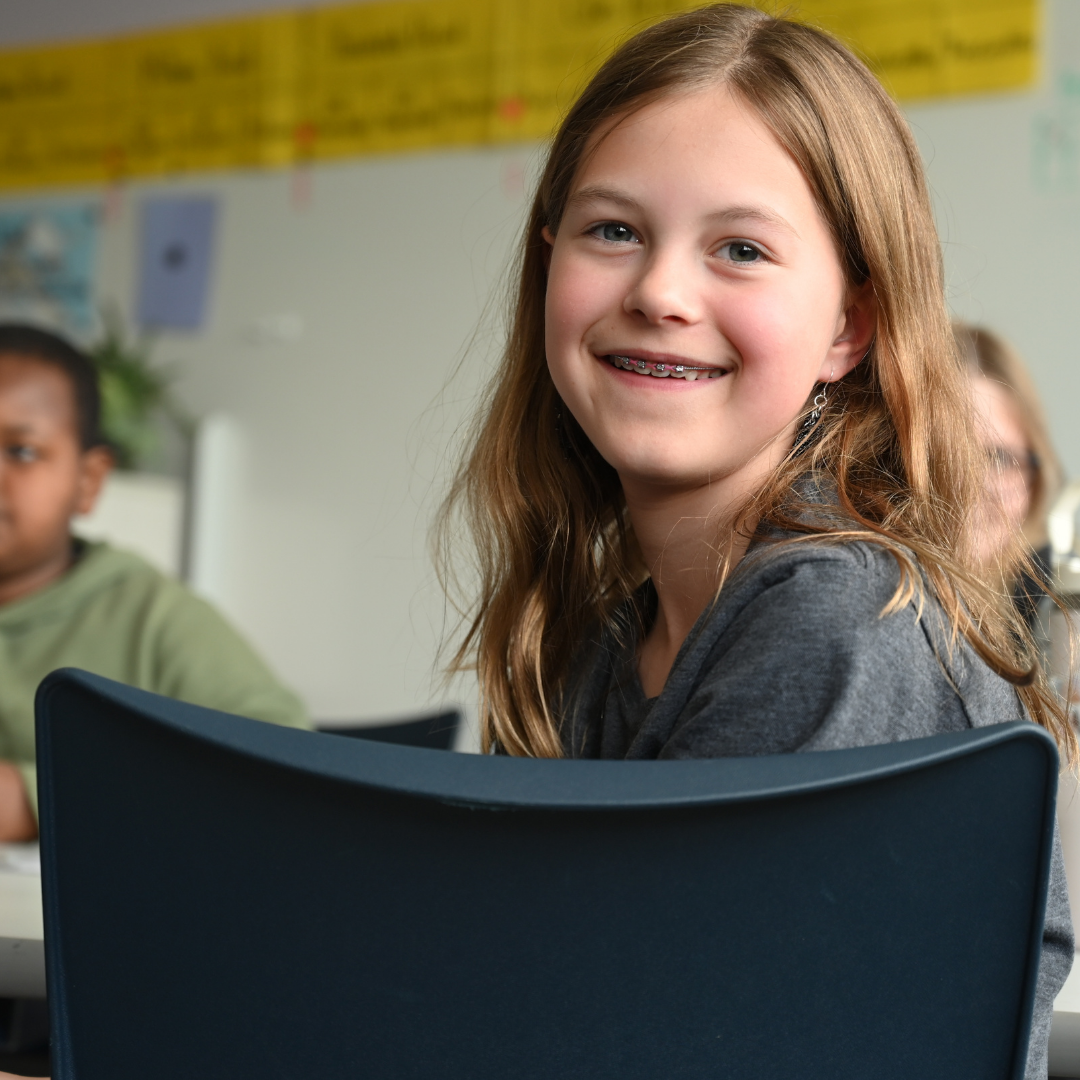 student turned around in chair smiling at the camera