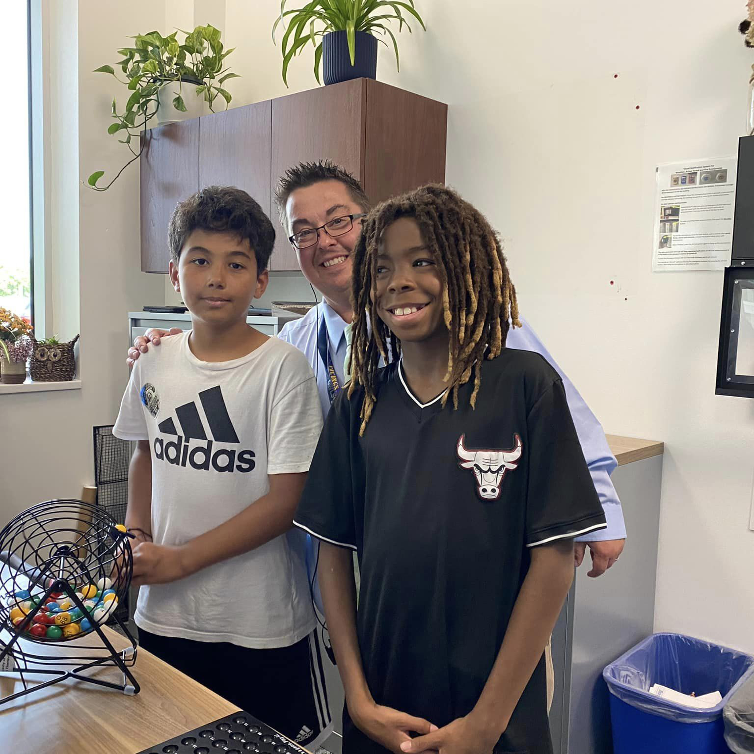 Two Overland students with Principal Groehler smiling at the camera