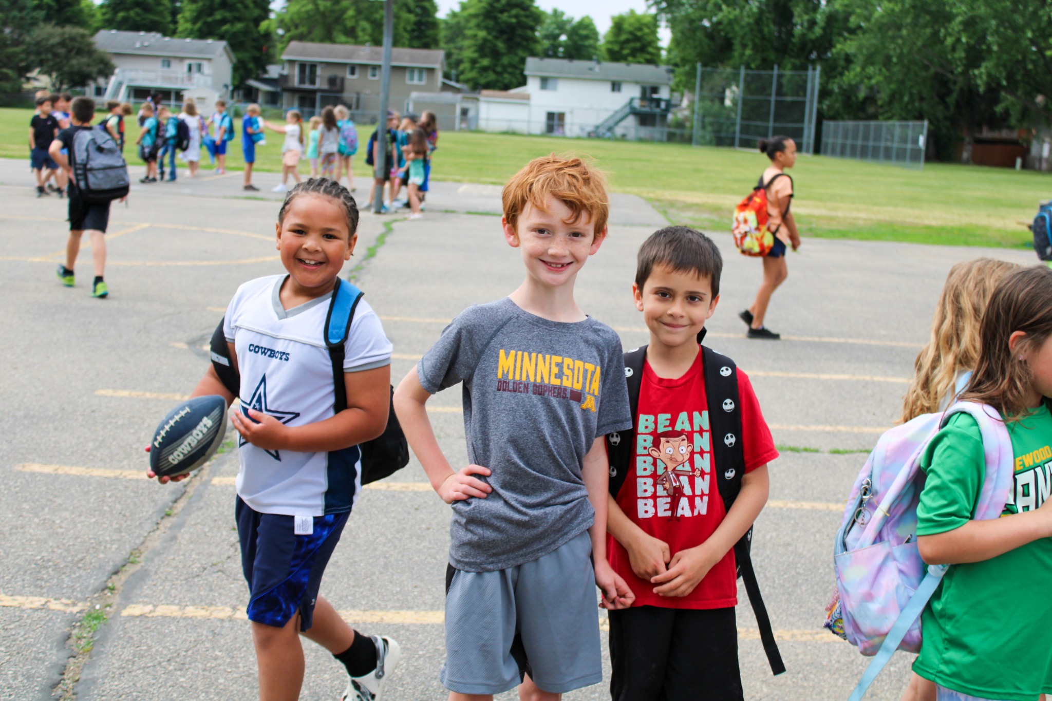 Students on the playground, posing and smiling at the camera